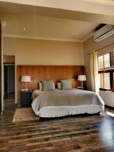 a bedroom with a large bed and two lamps at 391 Vaal de Grace Golf Estate, Parys in Parys