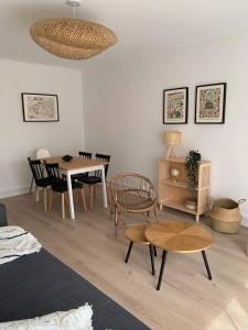 a living room with a table and a dining room at Appartement 40m2 vue sur mer accès direct plage et parking privé in Dinard