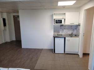 a kitchen with white cabinets and a microwave at Noisy Residence in Noisy-le-Grand