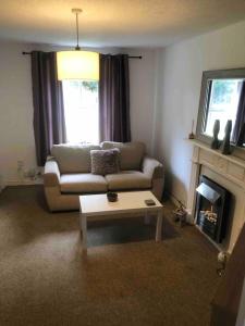a living room with a couch and a coffee table at Bluebell House 2 bedroom with parking and garden in Scunthorpe