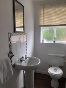 a white bathroom with a toilet and a sink at Bluebell House 2 bedroom with parking and garden in Scunthorpe