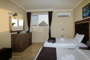 a hotel room with two beds and a mirror at King Cheops Inn - Pyramid View in Cairo