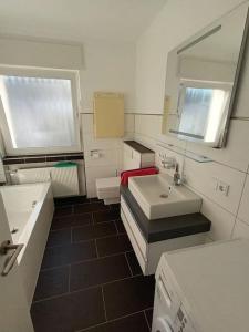 une salle de bain avec un lavabo et un miroir dans l'établissement Ferienwohnung 98mq, à Konz