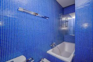 un bagno piastrellato blu con vasca e WC di Cozy apartment near the beach a Estoril Altre 18 foto