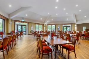 uma sala de jantar com mesas e cadeiras de madeira em Pine Lake Resort em Carnforth