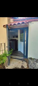 eine offene Tür eines Hauses mit einer Veranda in der Unterkunft Mazet en bord de ruisseau in Aumessas