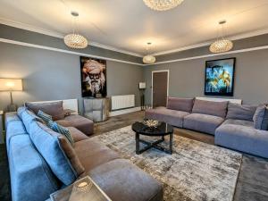 a large living room with couches and a table at Robert Bolt House in Sale