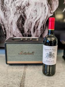 a bottle of wine sitting next to a speaker at Robert Bolt House in Sale