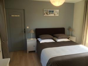 ein Schlafzimmer mit einem großen Bett mit zwei Nachttischen in der Unterkunft Le Galvani in Honfleur