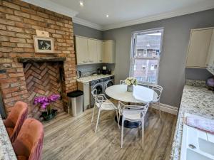 a kitchen with a table and a brick wall at Robert Bolt House in Sale