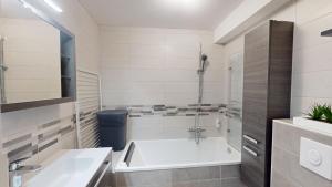 a bathroom with a tub and a sink at Studio Schilick in Schiltigheim