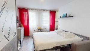 a small bedroom with red curtains and a bed at Studio Schilick in Schiltigheim