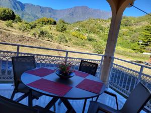 una mesa en un balcón con vistas a las montañas en Maison Créole Soalaze en Salazie