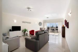 a living room with a couch and a table and a television at Vilamoura Marina in Vilamoura