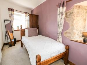 een slaapkamer met een wit bed in een paarse muur bij Valley View in Belper