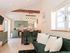 a living room with a green couch and a kitchen at The Nest in Bridgwater