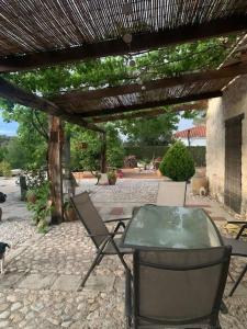 eine Terrasse mit einem Tisch und Stühlen unter einer Pergola in der Unterkunft Ven-Al-Azahar in Enguera