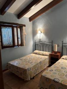 - une chambre avec 2 lits et une fenêtre dans l'établissement Ven-Al-Azahar, à Enguera
