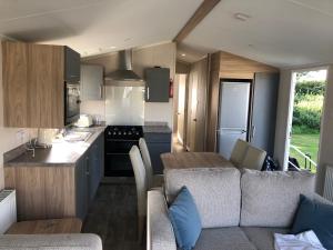 a kitchen with a couch and a table in a caravan at Beach house fun in Walton-on-the-Naze