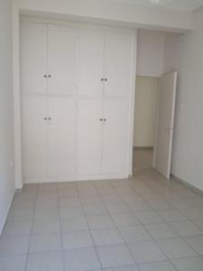 an empty room with white cabinets and a tiled floor at COMFORT RENT in Lamía