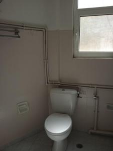 a bathroom with a white toilet and a window at COMFORT RENT in Lamía