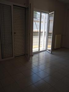 an empty room with doors and a tiled floor at COMFORT RENT in Lamía