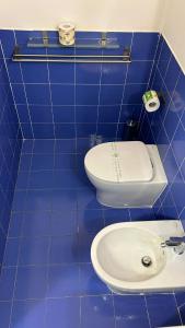 a blue tiled bathroom with a toilet and a sink at Vacanze romane in Rome