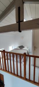 Ce lit superposé se trouve dans un dortoir doté d'une balustrade en bois. dans l'établissement Joli studio vue mer, à Menton