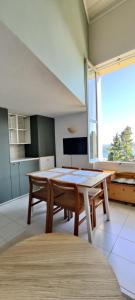 une salle à manger avec une table et une grande fenêtre dans l'établissement Joli studio vue mer, à Menton