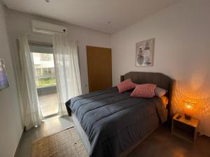 um quarto com uma cama com um candeeiro e uma janela em Au Cœur Des Sables D’or - Harhoura em Temara