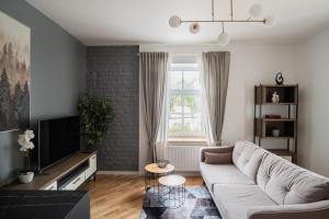 a living room with a couch and a tv at Homly S22 in Riga