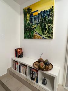 a white shelf with a bowl of fruit and a painting at Villa Ti MoOn, Entre deux, Piscine in LʼEntre-Deux