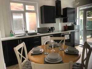 een keuken met een houten tafel met stoelen en een eetkamer bij 15 Comfort House 2 bed townhouse with parking in Scunthorpe