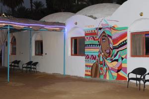 une fresque d'une femme sur le côté d'un bâtiment dans l'établissement Nile View Guest House, à Assouan