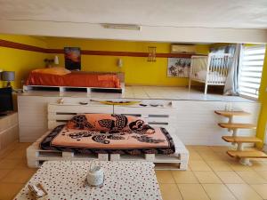 Zimmer mit 2 Etagenbetten und einem Tisch in der Unterkunft Gîtes TAINACO in Vieux-Habitants