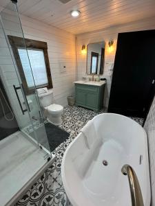 ein Badezimmer mit einer Badewanne, einem WC und einem Waschbecken in der Unterkunft Casita at the Winery in Battle Ground