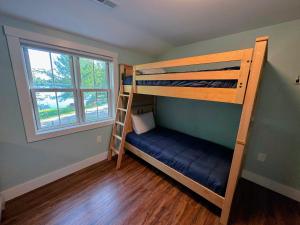 a bedroom with two bunk beds and a ladder at 91WR Lake vibes and views at this waterfront home in the the White Mountains! Rest, relax, explore! in Whitefield