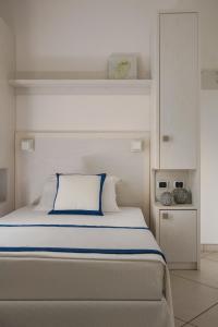 a bedroom with a large bed with a blue pillow at Hotel Embassy in Riccione