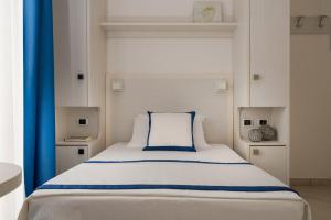 a bedroom with a large bed with a blue curtain at Hotel Embassy - Nuova Gestione 2026 in Riccione +60 photos