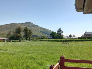 a bench in a field with a hill in the background at Havana Holiday Cottage Inishowen 