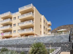 un grand bâtiment jaune avec des balcons blancs dans l'établissement Amazing & Chill Terrace Palm Mar, à Palm-mar