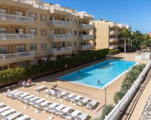 un hôtel avec une piscine devant un bâtiment dans l'établissement Amazing & Chill Terrace Palm Mar, à Palm-mar