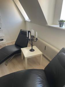 a living room with two chairs and a table with candles at Hotel Vin & Gastro in Aabenraa