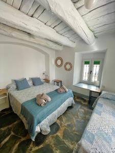 Un dormitorio con una cama grande con dos animales de peluche. en Tinoquero VTAR en Fuenteheridos