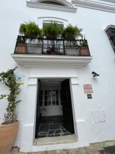 un edificio blanco con un balcón con macetas. en Tinoquero VTAR, en Fuenteheridos