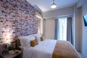 a bedroom with a brick wall and a bed at Nantin Hotel Ioannina in Ioannina