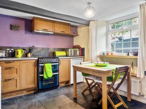 a kitchen with a table and a blue oven at Pass the Keys Quaint Cottage Retreat in Charming Ulverston in Ulverston