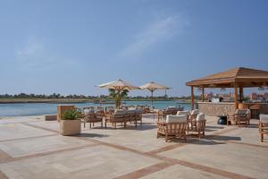 a patio with chairs and umbrellas next to the water at Steigenberger Golf Resort El Gouna in Hurghada