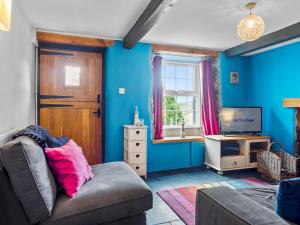 a living room with a couch and a tv at Pass the Keys Quaint Cottage Retreat in Charming Ulverston in Ulverston