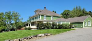 uma grande casa verde com um jardim relvado em 68CP Luxury farmhouse at the award-winning Bellevue Barn, 2 min to Santa's Village, AC, fireplace em Jefferson